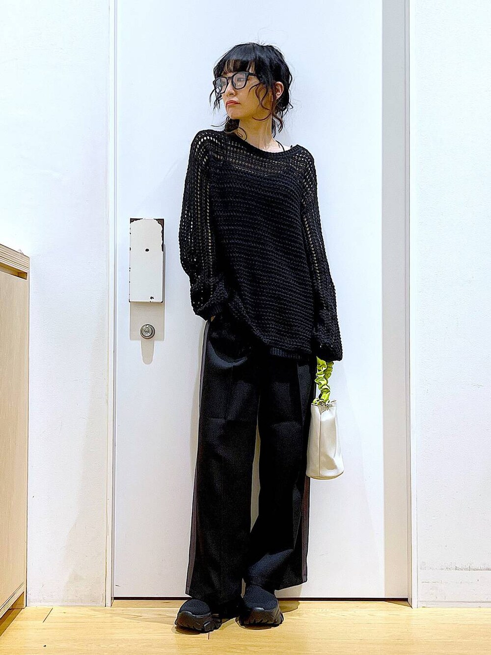 グリーン系のショルダーバッグ、ブラック系のその他パンツ、ブラック系のスニーカーを着用したレディースの春コーディネートの2枚目の写真