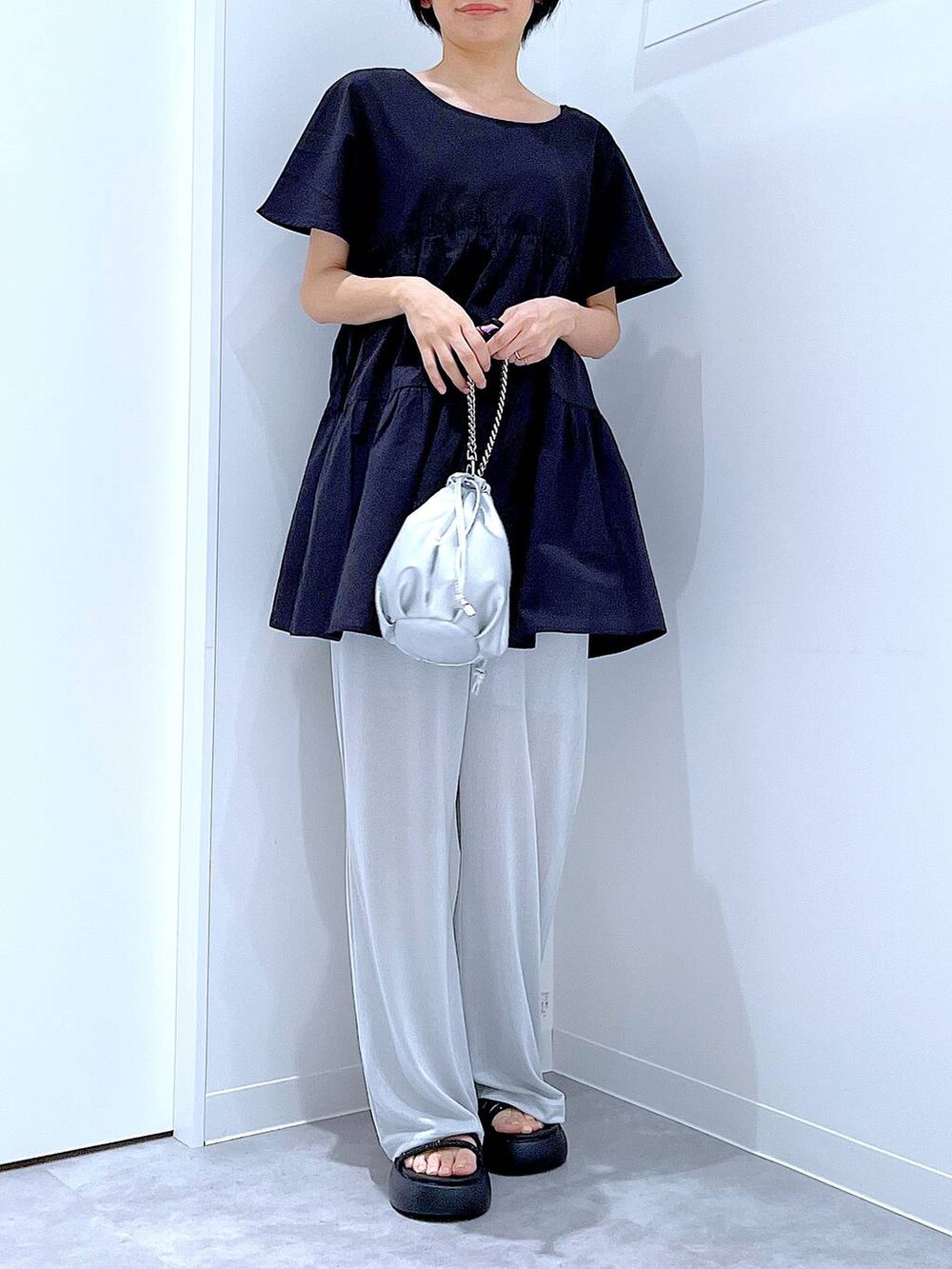 シルバー系のショルダーバッグ、ブラック系のサンダル、グレー系のその他パンツを着用したレディースの夏コーディネートの5枚目の写真