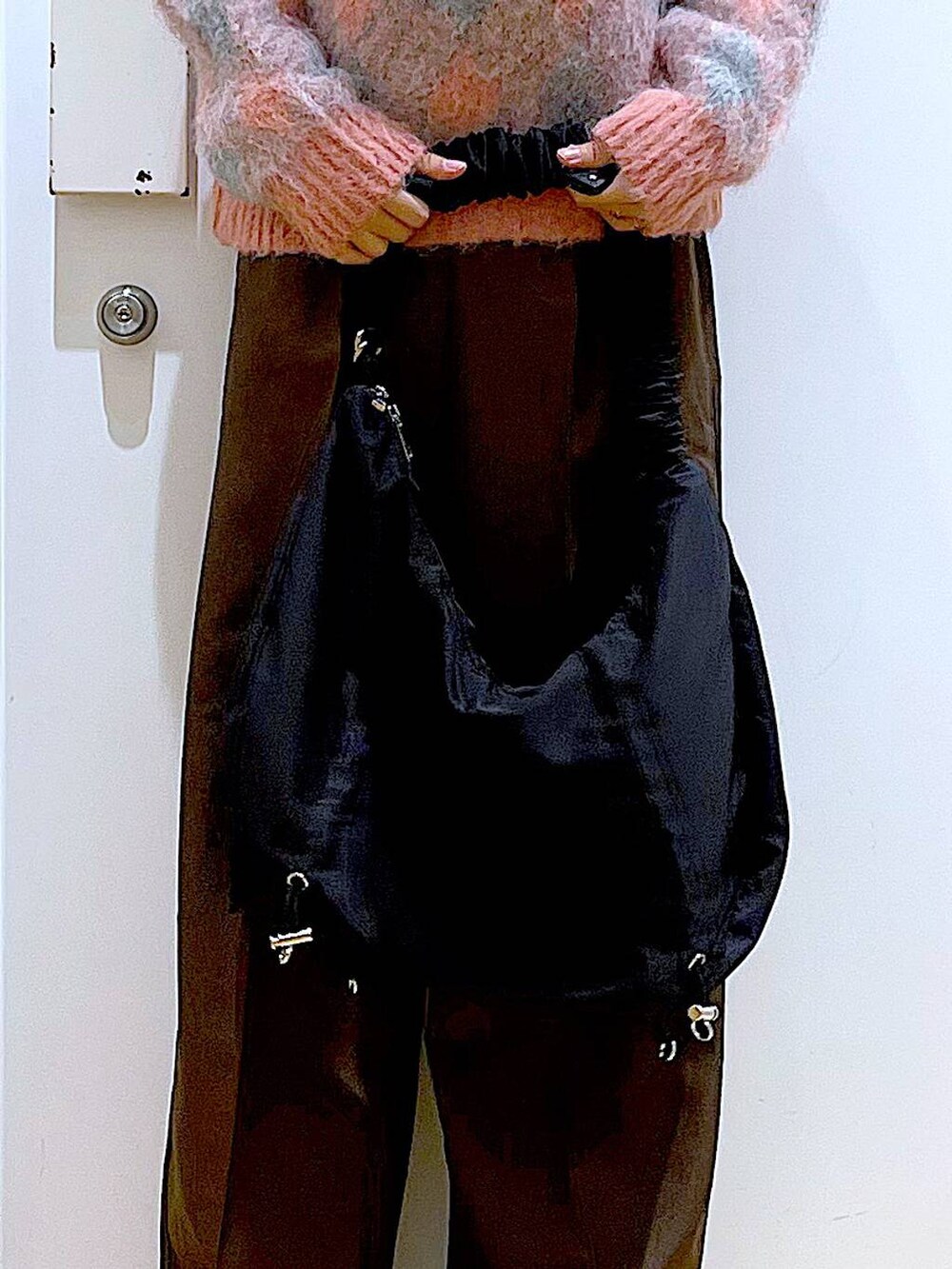 ブラック系のブーツ、ブラック系のショルダーバッグ、ピンク系のニット/セーターを着用したレディースの冬コーディネートの8枚目の写真