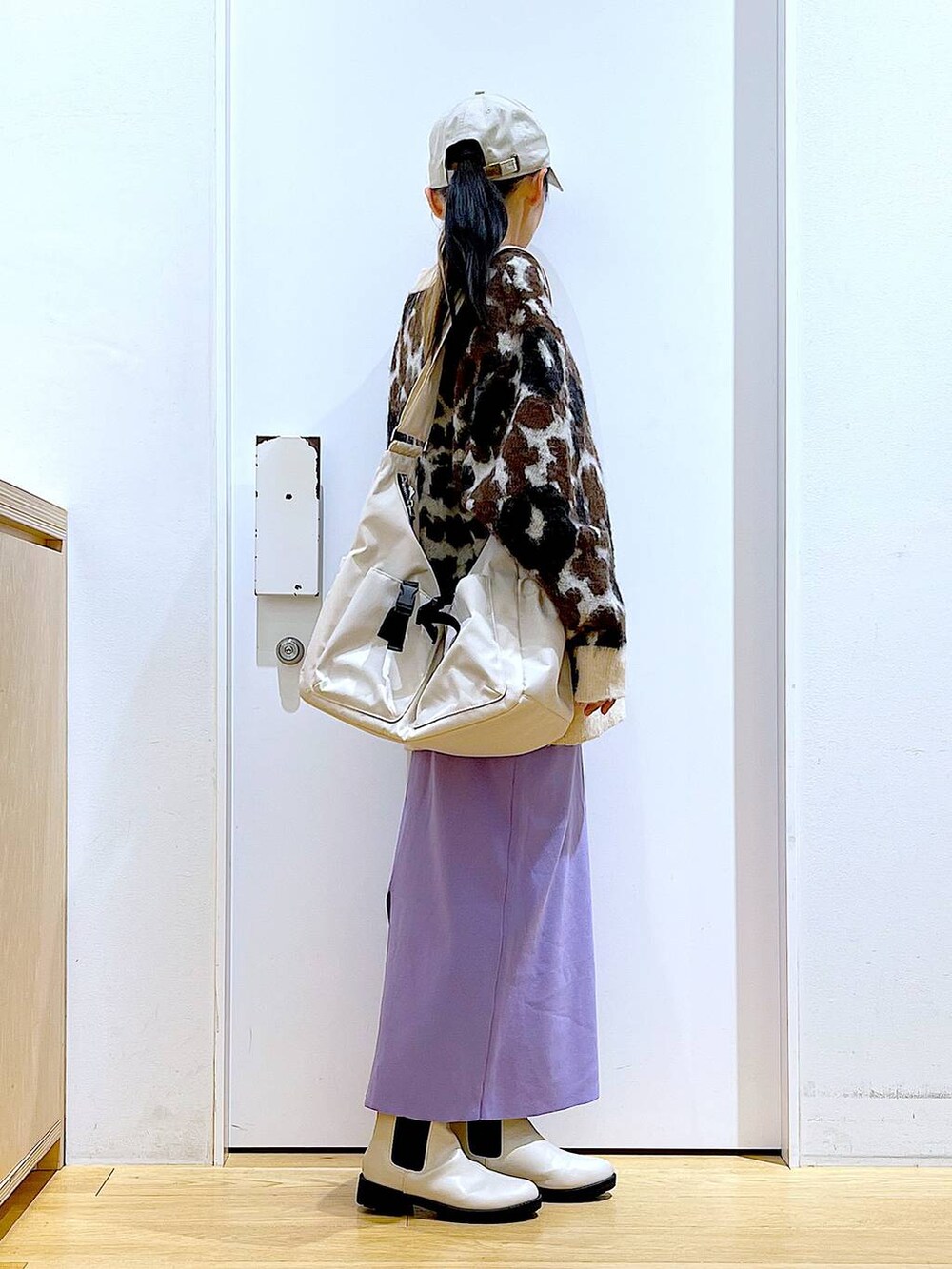 ホワイト系のTシャツ/カットソー、ベージュ系のブーツ、ベージュ系のショルダーバッグを着用したレディースの冬コーディネートの4枚目の写真