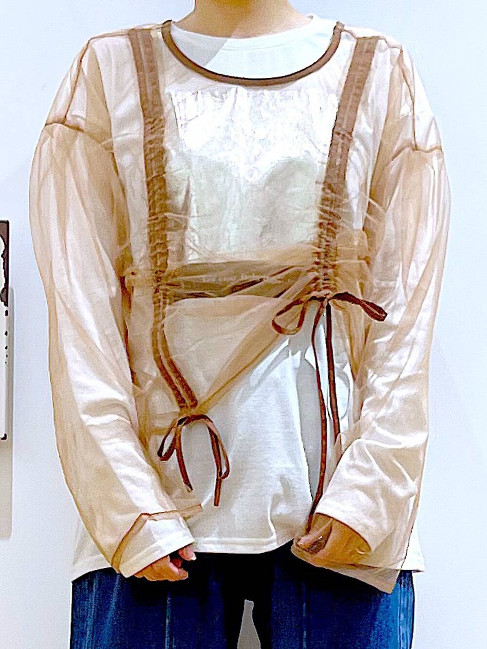 ホワイト系のショルダーバッグ、ホワイト系のパンプス、ブルー系のデニムパンツを着用したレディースの秋コーディネートの7枚目の写真