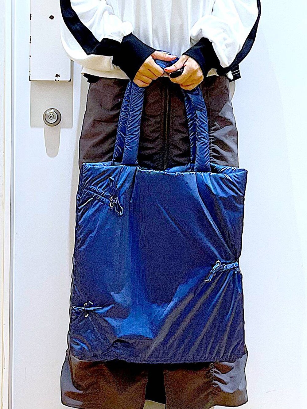 ブラック系のブーツ、ブルー系のトートバッグ、ホワイト系のTシャツ/カットソーを着用したレディースの秋コーディネートの9枚目の写真