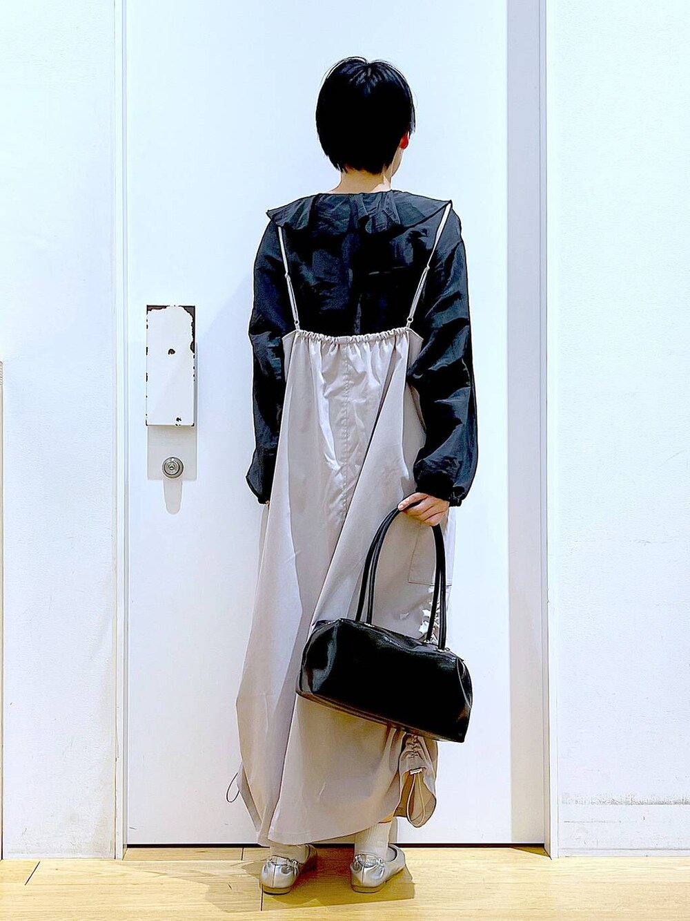 ブラック系のボストンバッグ、シルバー系のパンプス、グレー系のシャツ/ブラウスを着用したレディースの春コーディネートの5枚目の写真