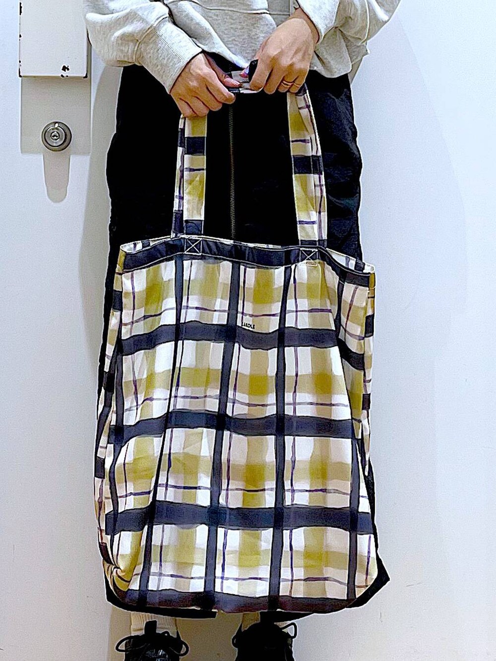 ブラック系のスカート、ブラック系のスニーカー、その他のトートバッグを着用したレディースの春コーディネートの9枚目の写真