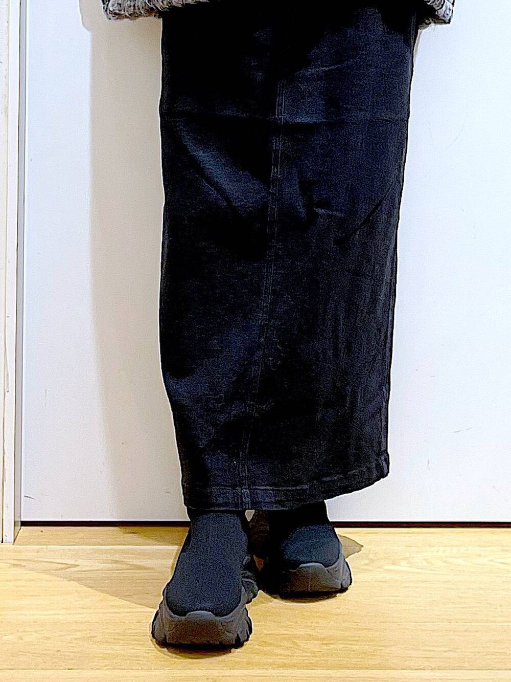 グレー系のジャンパースカート、ブラック系のブーツ、ブラック系のショルダーバッグを着用したレディースの冬コーディネートの8枚目の写真