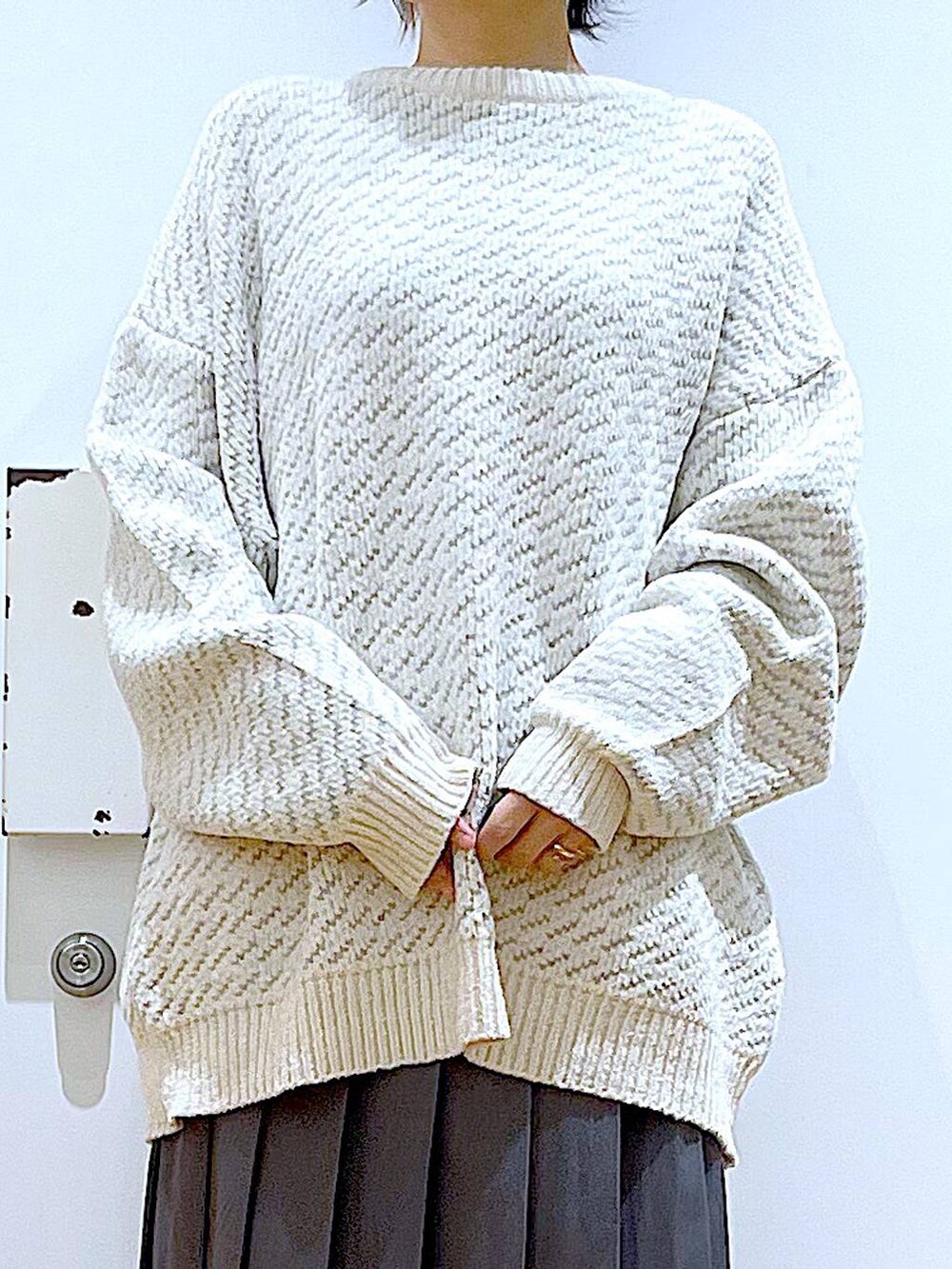 ベージュ系のニット/セーター、ピンク系のショルダーバッグ、ブラック系のブーツを着用したレディースの冬コーディネートの7枚目の写真