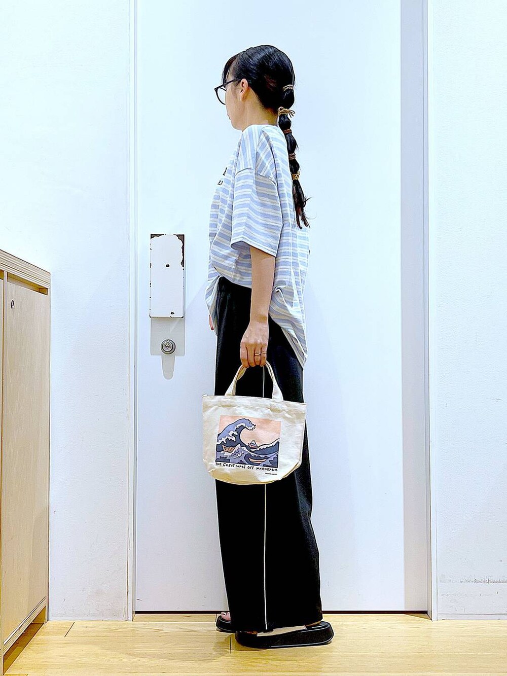 シルバー系のサンダル、その他のトートバッグ、ブルー系のTシャツ/カットソーを着用したレディースの夏コーディネートの3枚目の写真