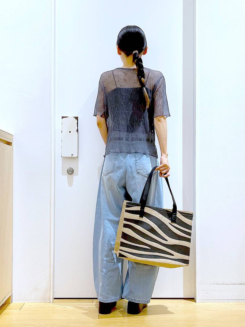 ブルー系のデニムパンツ、その他のトートバッグ、ブラック系のサンダルを着用したレディースの夏コーディネートの5枚目の写真