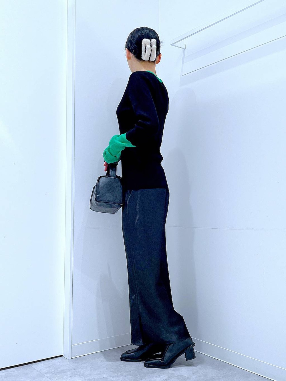 ブラック系のブーツ、ブラック系のショルダーバッグ、ブラック系のニット/セーターを着用したレディースの冬コーディネートの3枚目の写真