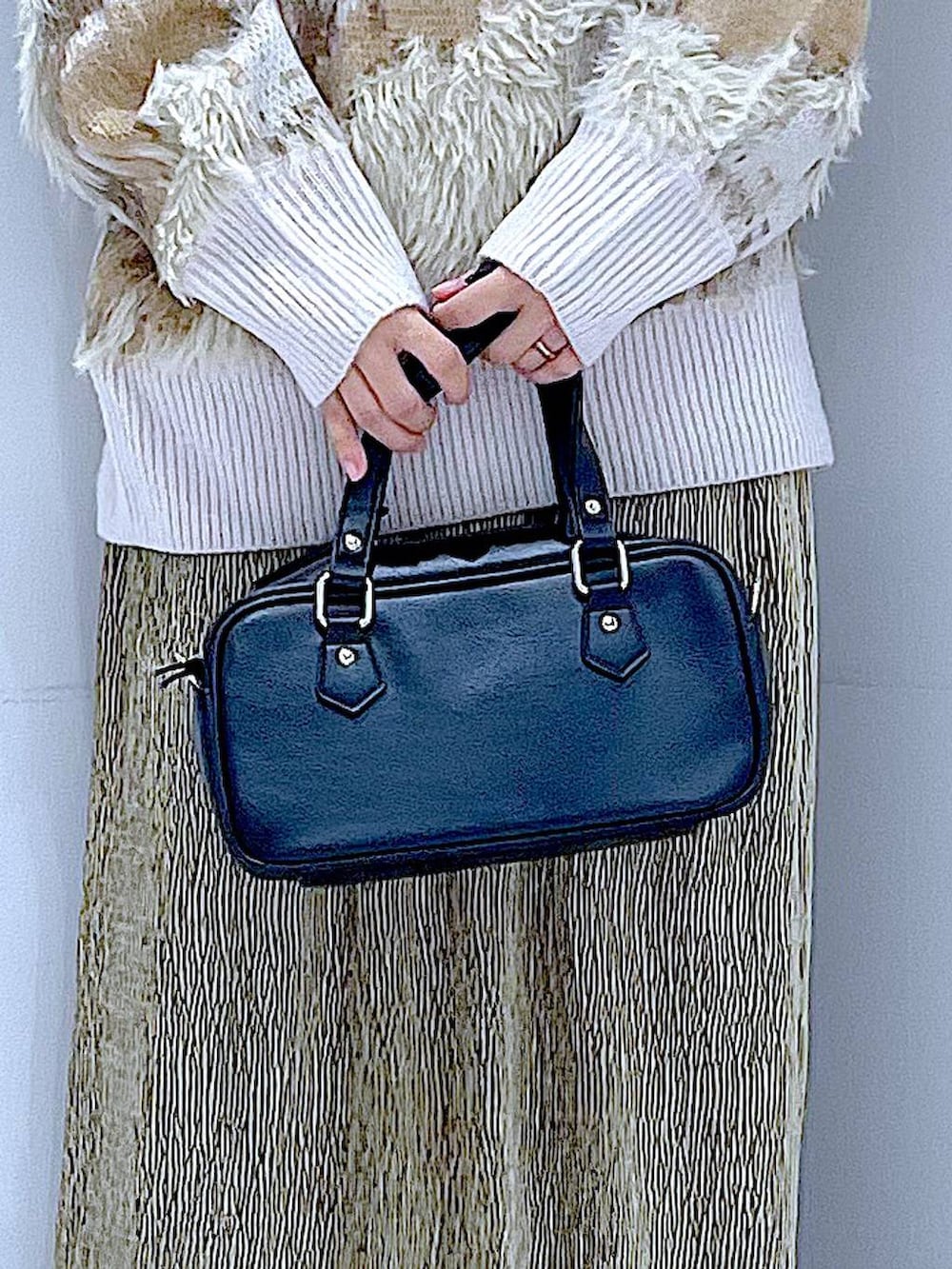 ブラック系のブーツ、ブラック系のショルダーバッグ、グリーン系のスカートを着用したレディースの冬コーディネートの9枚目の写真