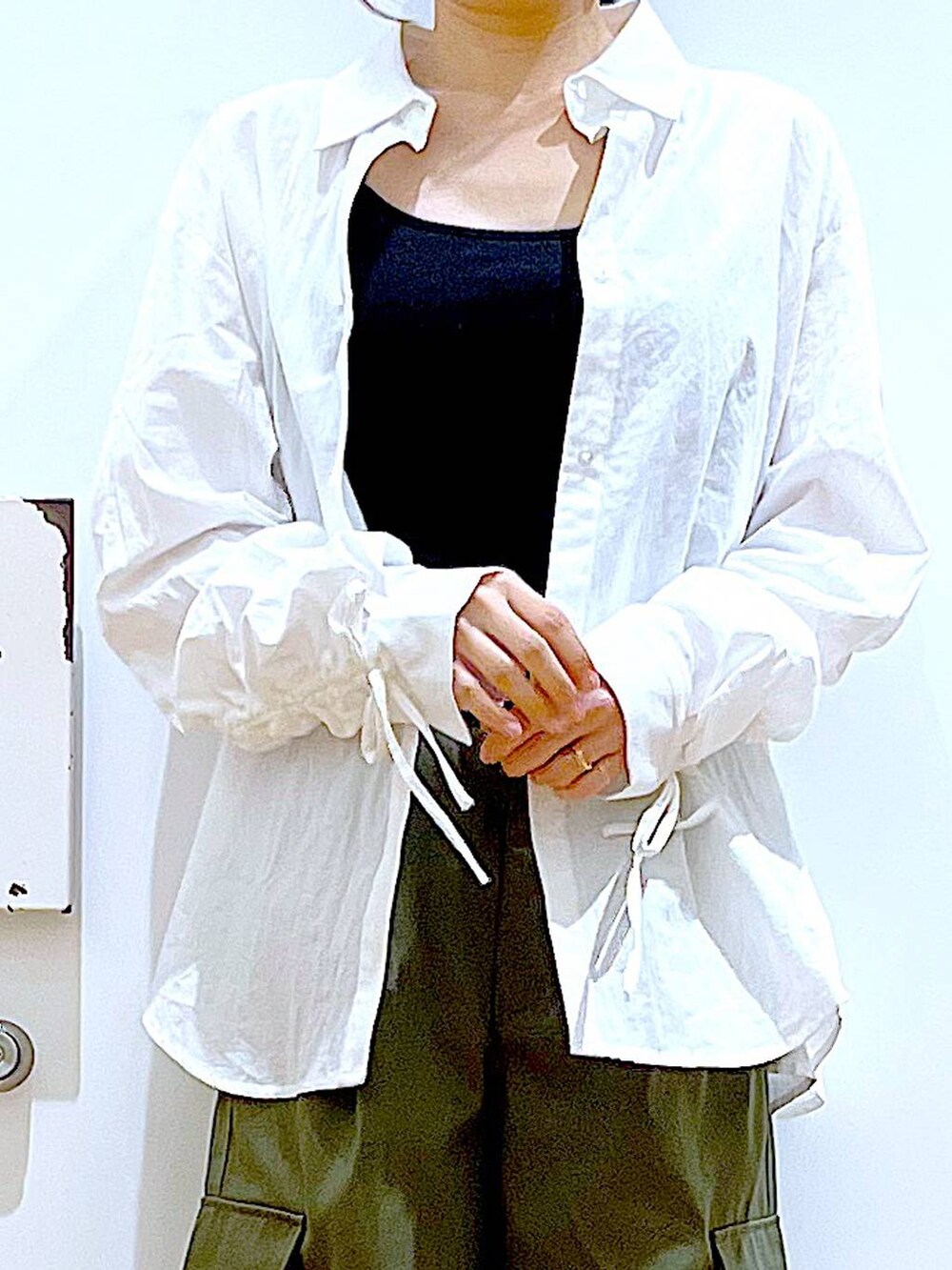 ホワイト系のシャツ/ブラウス、ホワイト系のショルダーバッグ、ベージュ系のスニーカーを着用したレディースの春コーディネートの7枚目の写真