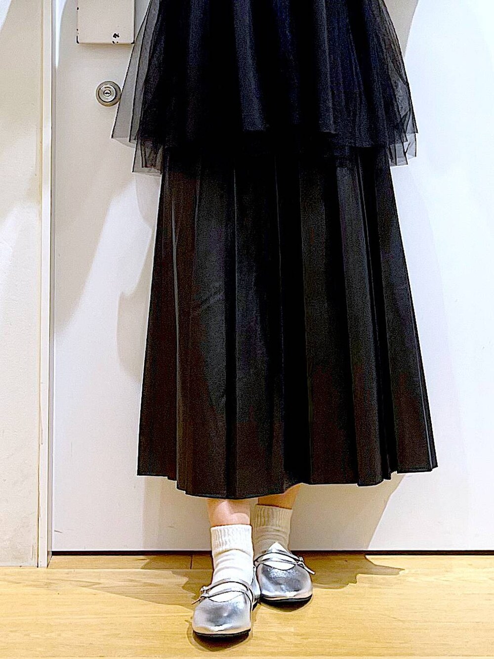 ホワイト系のショルダーバッグ、シルバー系のパンプス、ブラック系のスカートを着用したレディースの秋コーディネートの8枚目の写真