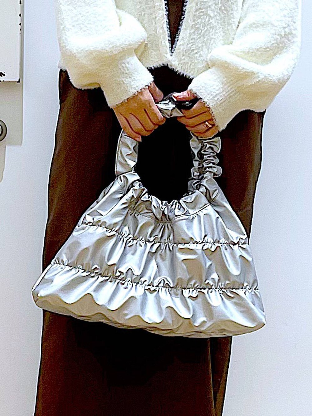 ベージュ系のニット/セーター、ベージュ系のブーツ、ブラウン系のサロペット/オーバーオールを着用したレディースの冬コーディネートの9枚目の写真