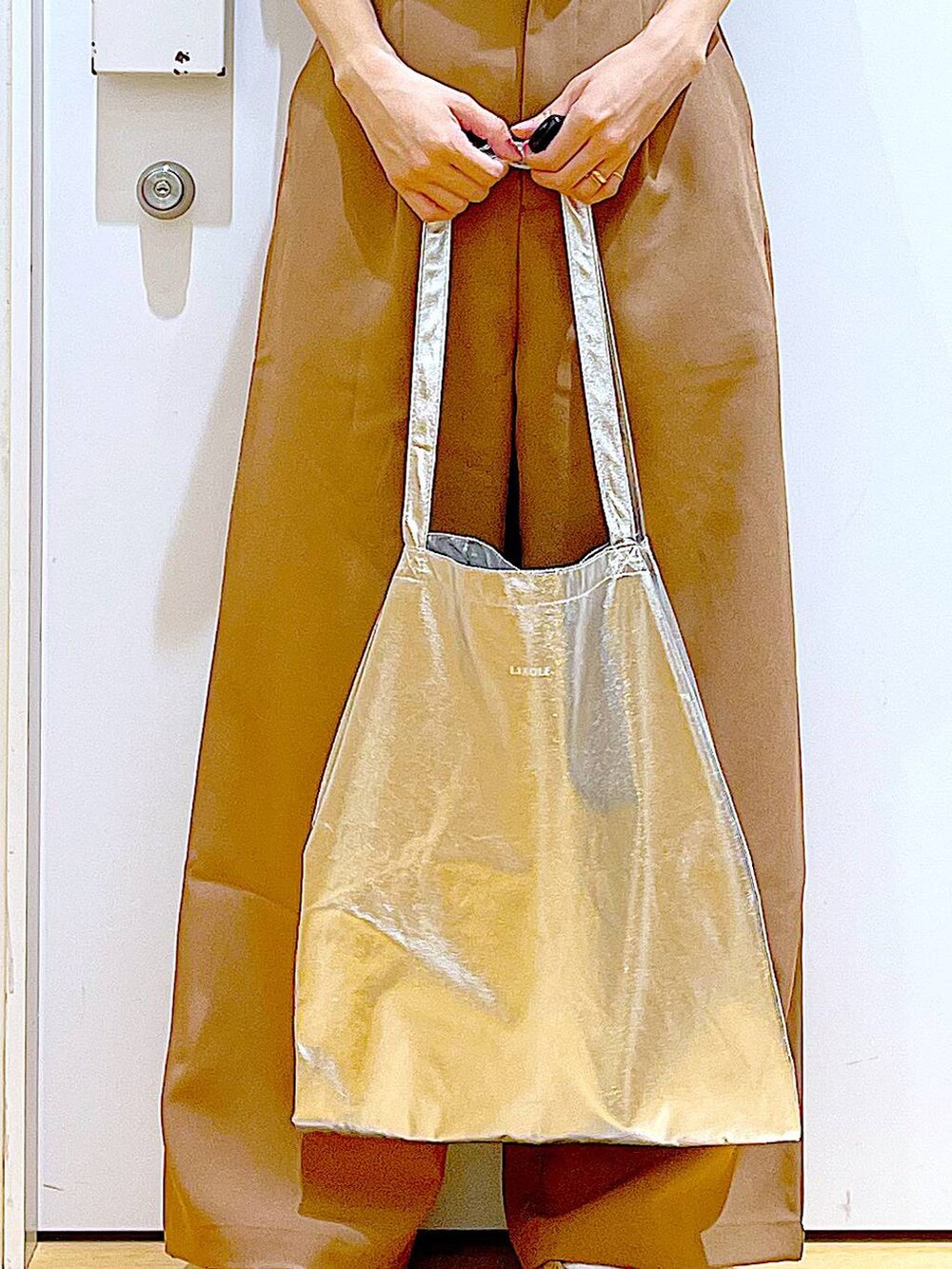 シルバー系のトートバッグ、ベージュ系のパンプス、ブラウン系のその他パンツを着用したレディースの春コーディネートの9枚目の写真