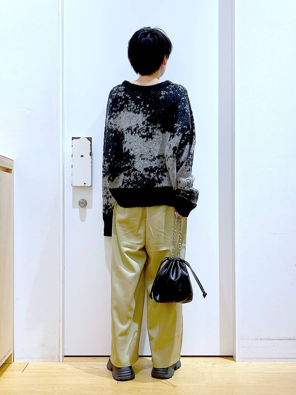 ブラック系のショルダーバッグ、ブラック系のブーツ、イエロー系のその他パンツを着用したレディースの冬コーディネートの5枚目の写真