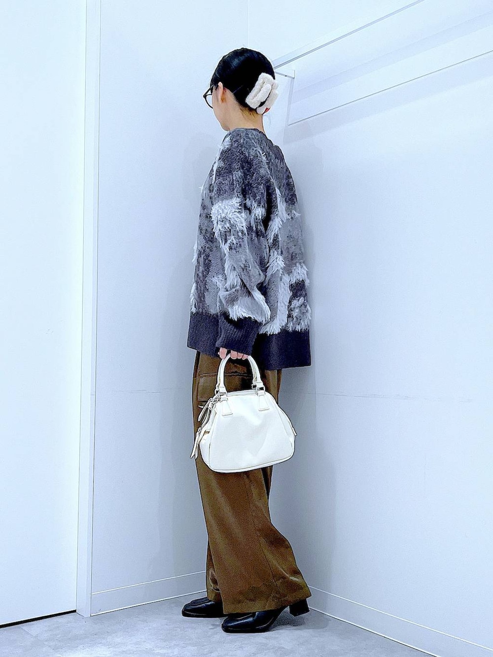 ブラック系のニット/セーター、ブラック系のブーツ、ブラック系のショルダーバッグを着用したレディースの秋コーディネートの3枚目の写真