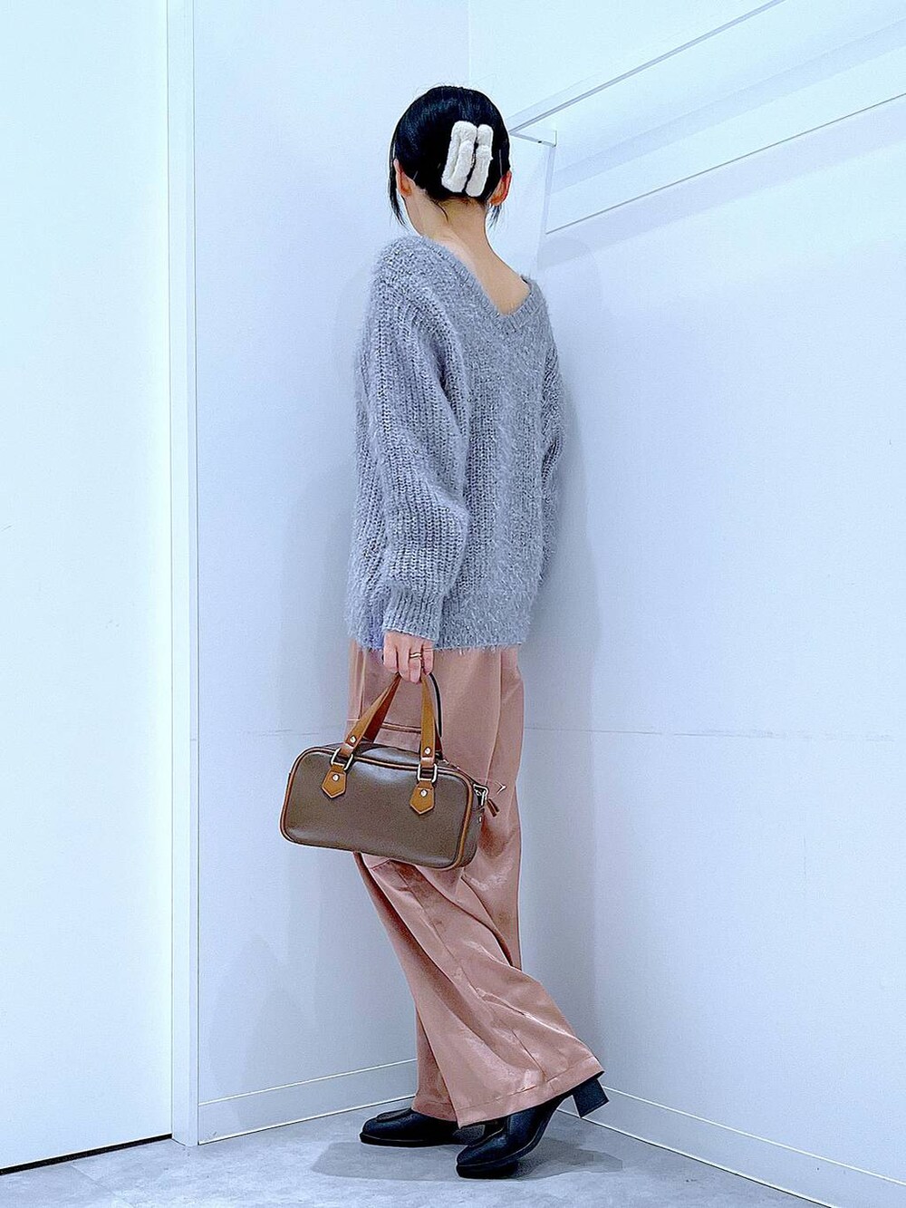 ブラック系のブーツ、ブラウン系のショルダーバッグ、ピンク系のカーゴパンツを着用したレディースの冬コーディネートの3枚目の写真