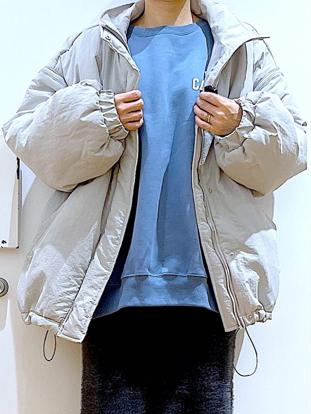 ブラック系のブーツ、ブルー系のスウェット、ブラック系のショルダーバッグを着用したレディースの冬コーディネートの7枚目の写真