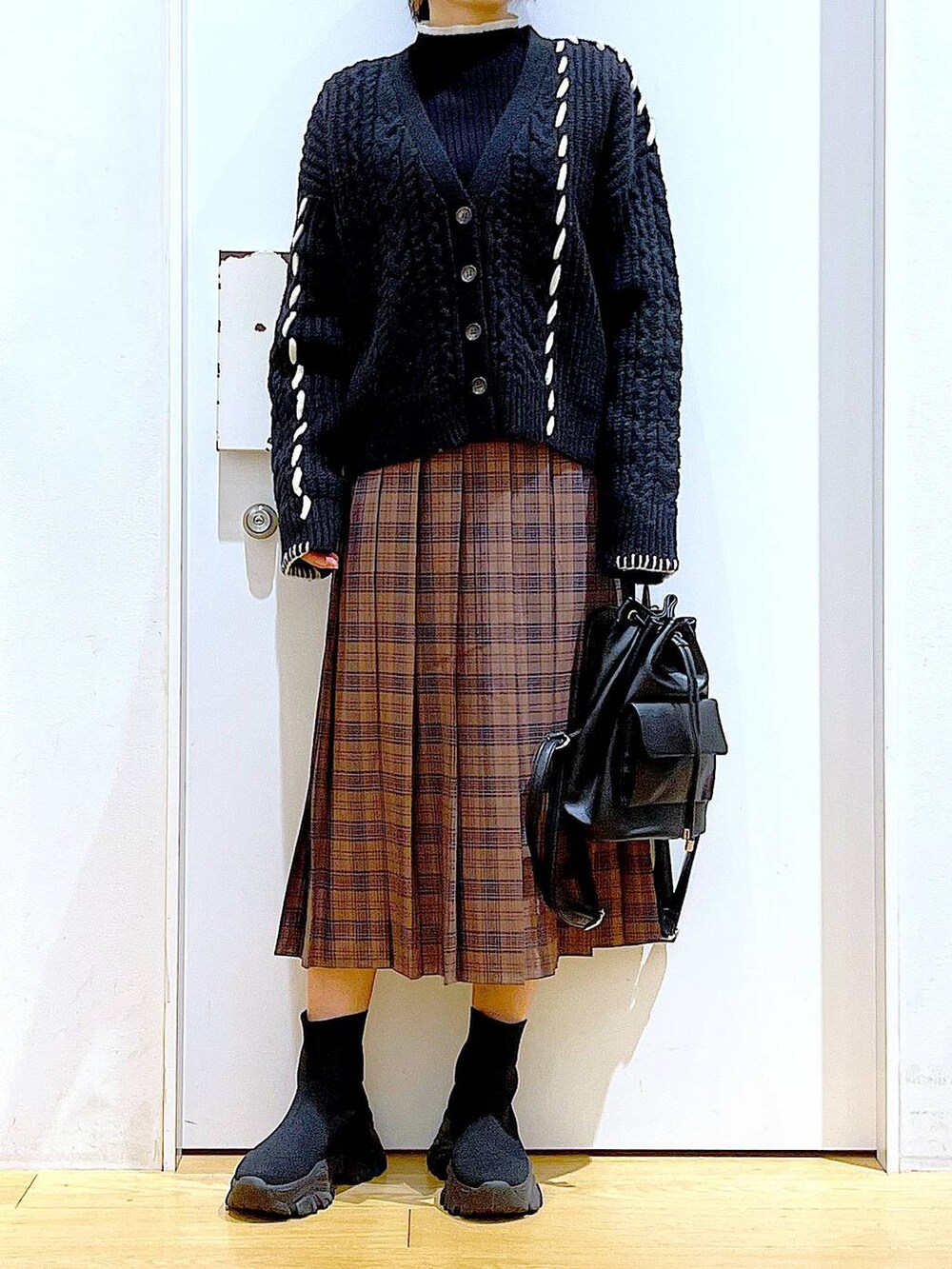 ブラック系のニット/セーター、ブラック系のバックパック/リュック、ブラック系のブーツを着用したレディースの冬コーディネートの6枚目の写真