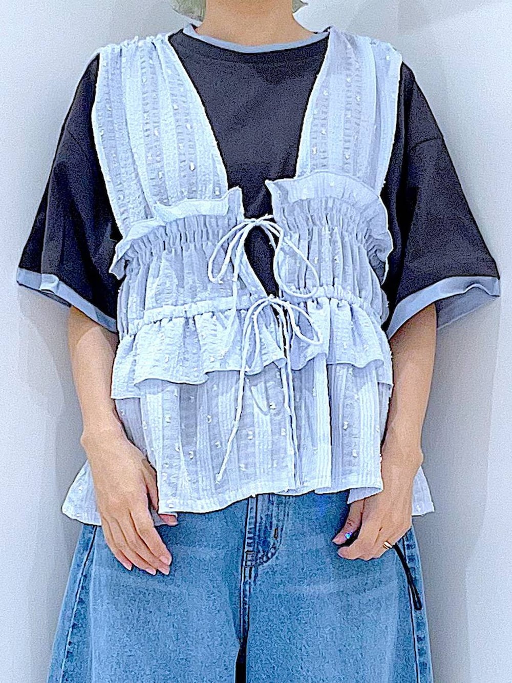 グレー系のTシャツ/カットソー、ブルー系のデニムパンツ、ブルー系のベストを着用したレディースの夏コーディネートの7枚目の写真