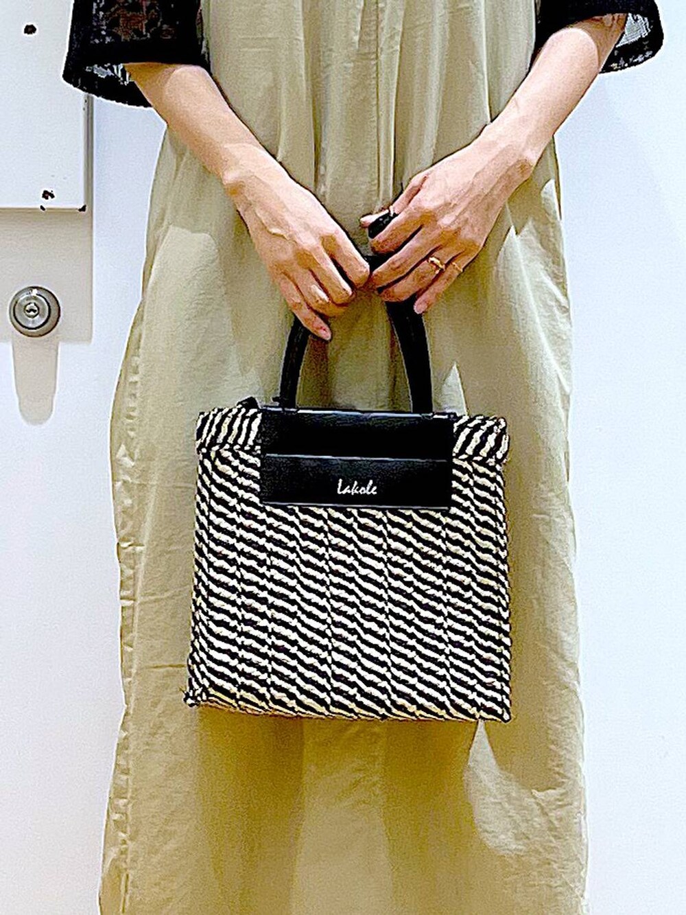 ベージュ系のワンピース、ブラック系のシャツ/ブラウス、ブラック系のパンプスを着用したレディースの春コーディネートの9枚目の写真