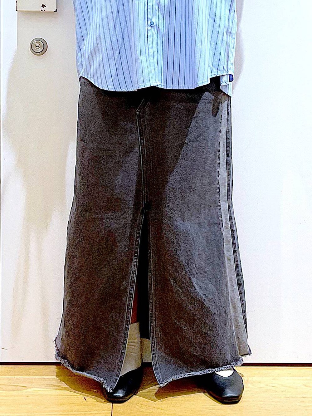 ブラック系のパンプス、ブラック系のデニムスカート、ブラック系のショルダーバッグを着用したレディースの春コーディネートの8枚目の写真