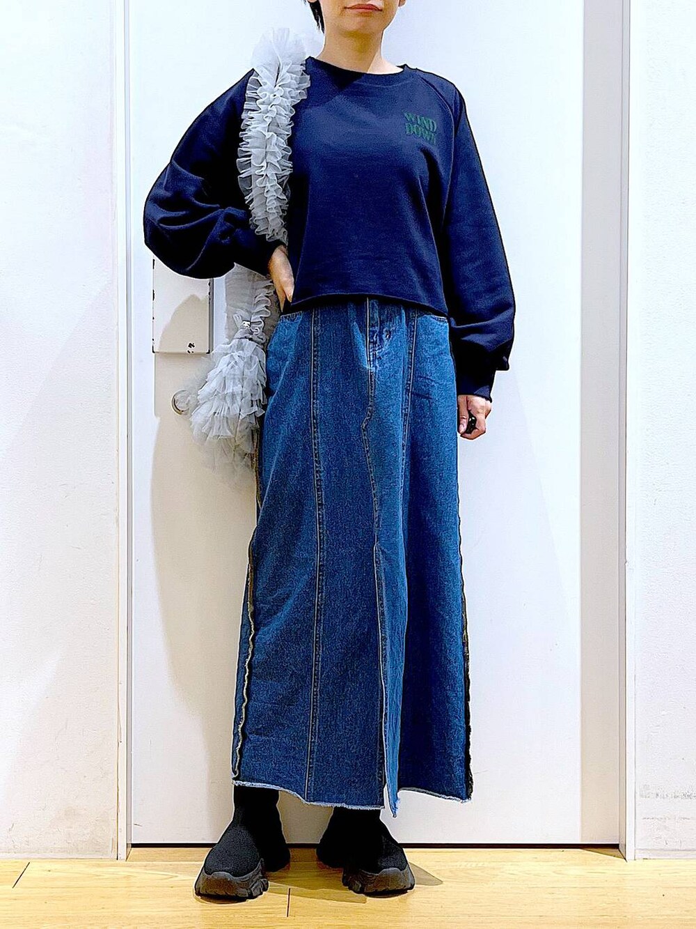 ブルー系のデニムスカート、ブラック系のブーツ、グレー系のショルダーバッグを着用したレディースの冬コーディネートの6枚目の写真