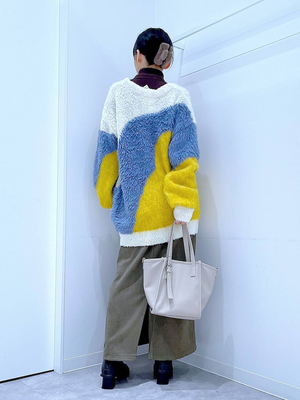 イエロー系のカーディガン/ボレロ、ブラック系のブーツ、グリーン系のスカートを着用したレディースの冬コーディネートの5枚目の写真