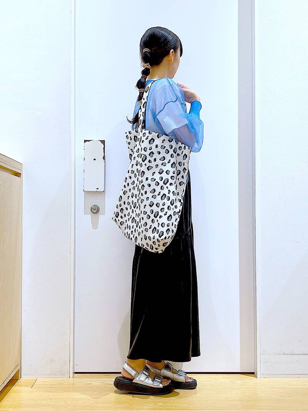 シルバー系のサンダル、ブルー系のカーディガン/ボレロ、ホワイト系のトートバッグを着用したレディースの夏コーディネートの4枚目の写真