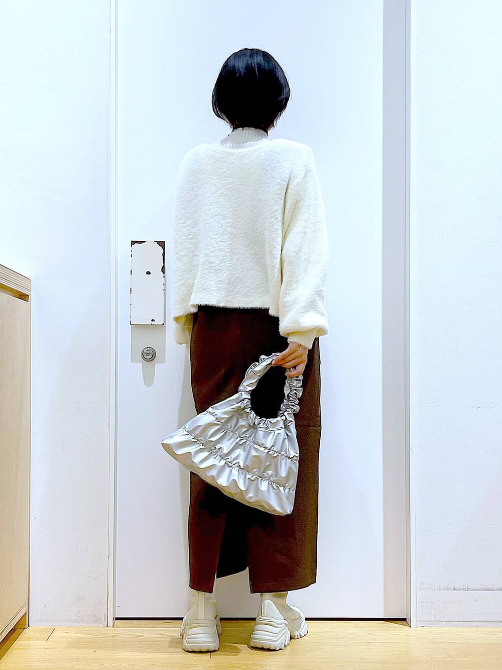 ベージュ系のニット/セーター、ベージュ系のブーツ、ブラウン系のサロペット/オーバーオールを着用したレディースの冬コーディネートの5枚目の写真