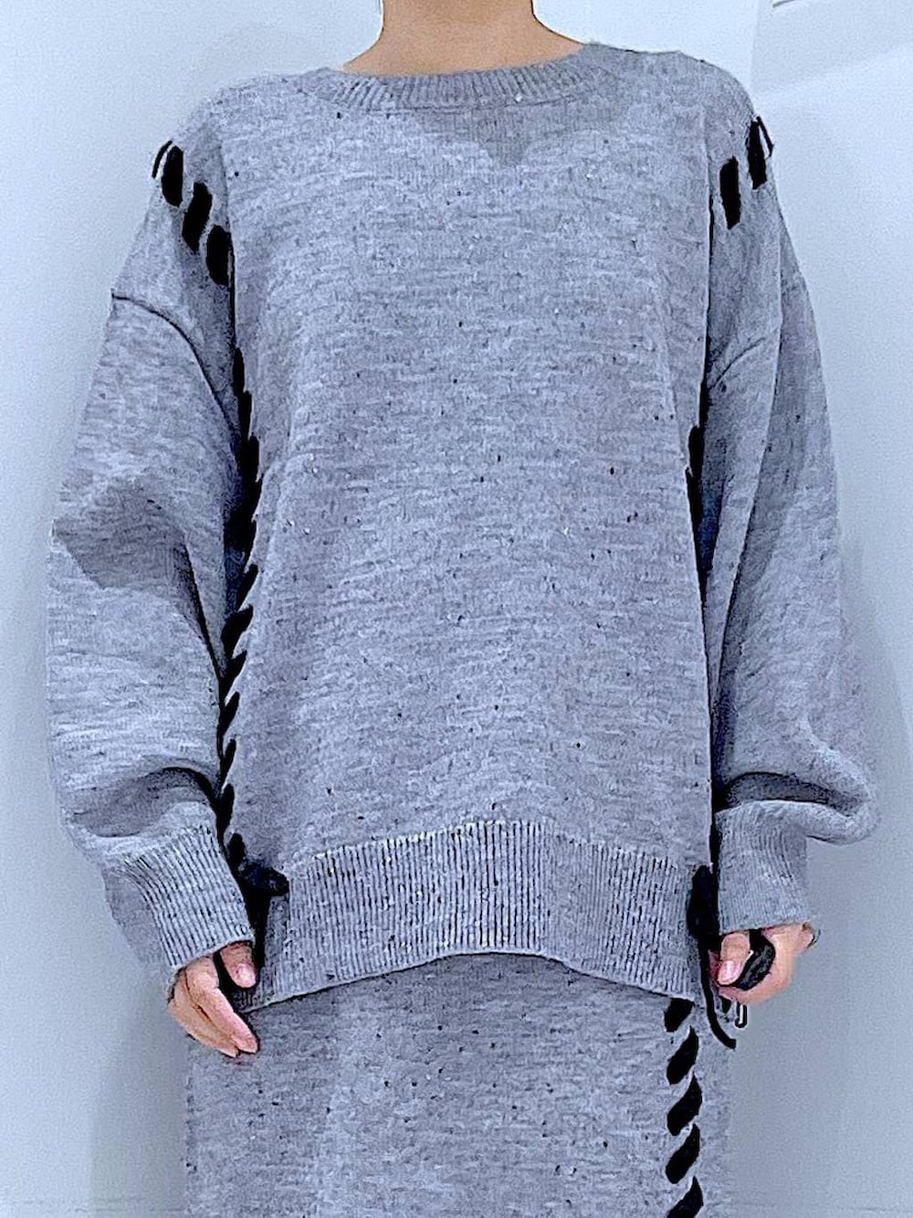 グレー系のニット/セーター、レッド系のショルダーバッグ、グレー系のスカートを着用したレディースの冬コーディネートの7枚目の写真