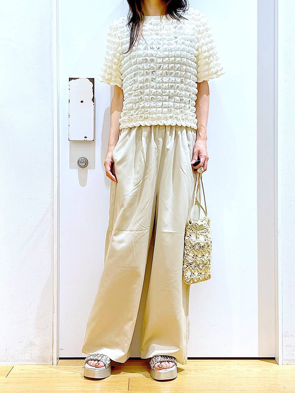 シルバー系のサンダル、ベージュ系のショルダーバッグ、ベージュ系のTシャツ/カットソーを着用したレディースの夏コーディネートの6枚目の写真