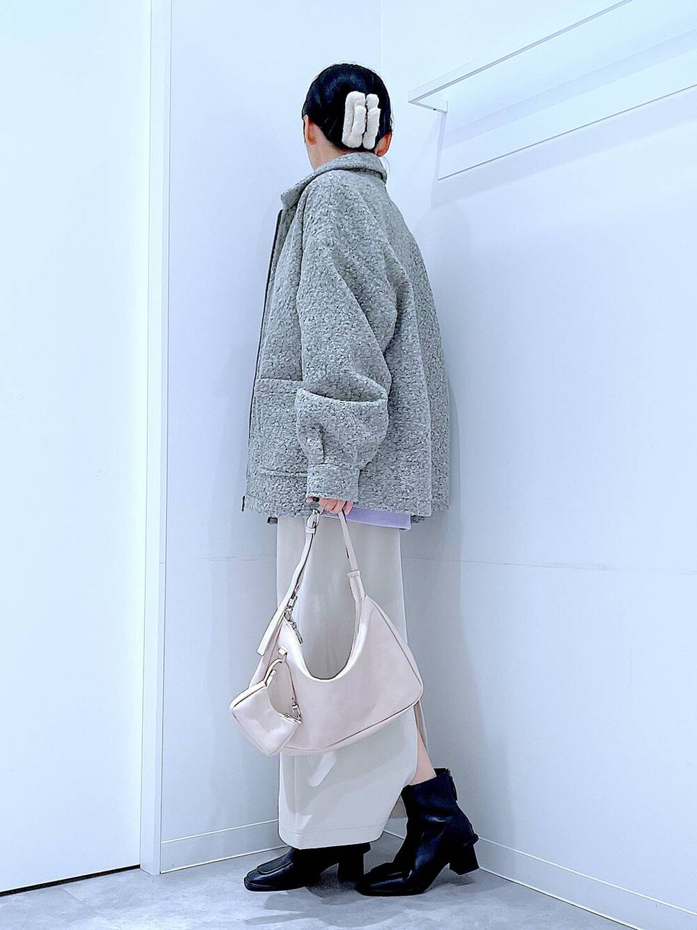 ベージュ系のスカート、グレー系のブルゾン、ブラック系のブーツを着用したレディースの秋コーディネートの3枚目の写真