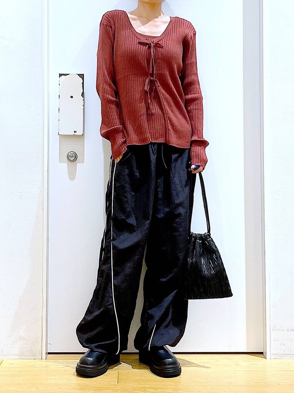 ブラック系のショルダーバッグ、ブラック系のブーツ、ブラウン系のカーディガン/ボレロを着用したレディースの秋コーディネートの6枚目の写真