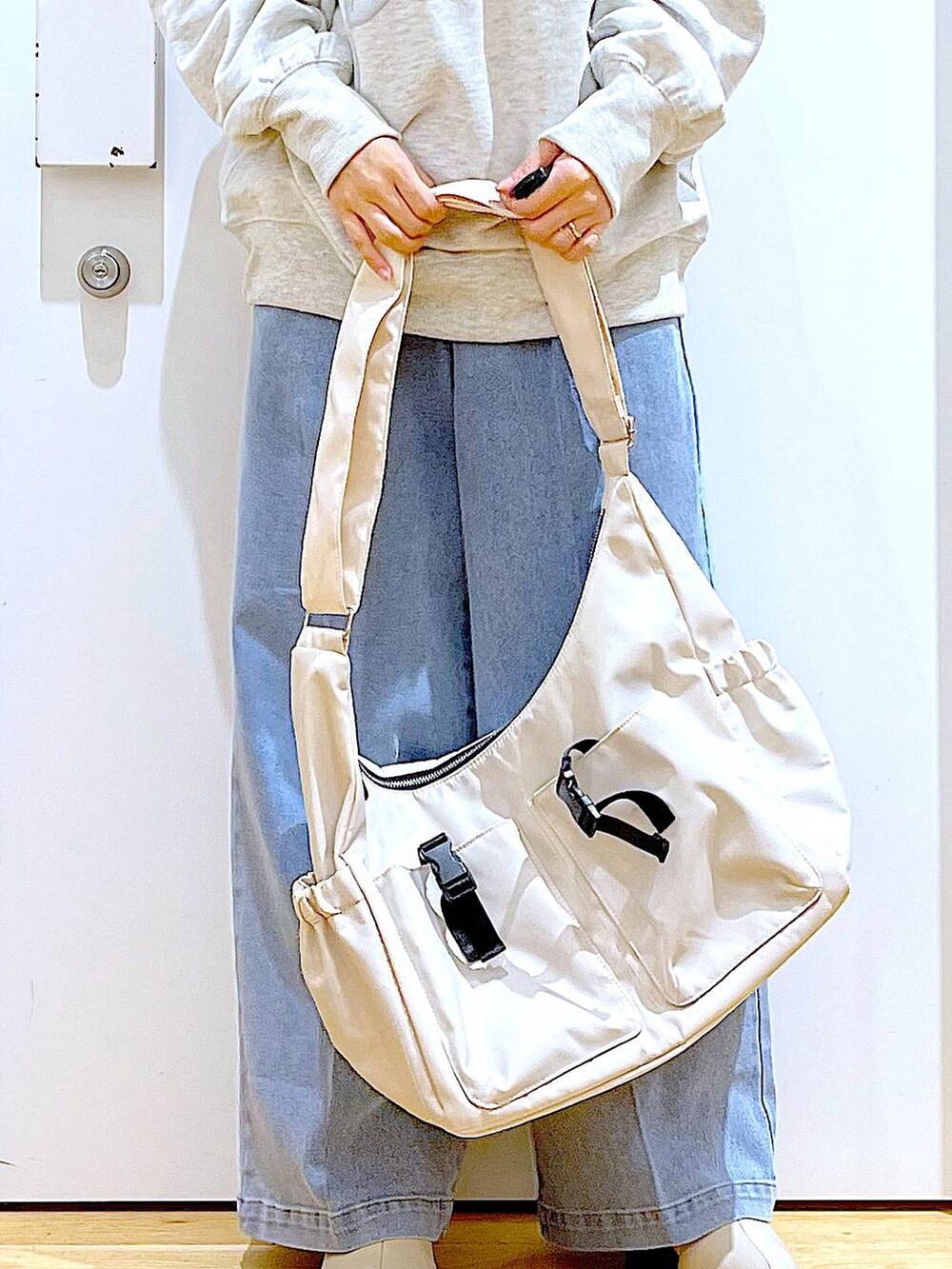 ブルー系のデニムパンツ、ベージュ系のスウェット、ベージュ系のブーツを着用したレディースの冬コーディネートの9枚目の写真