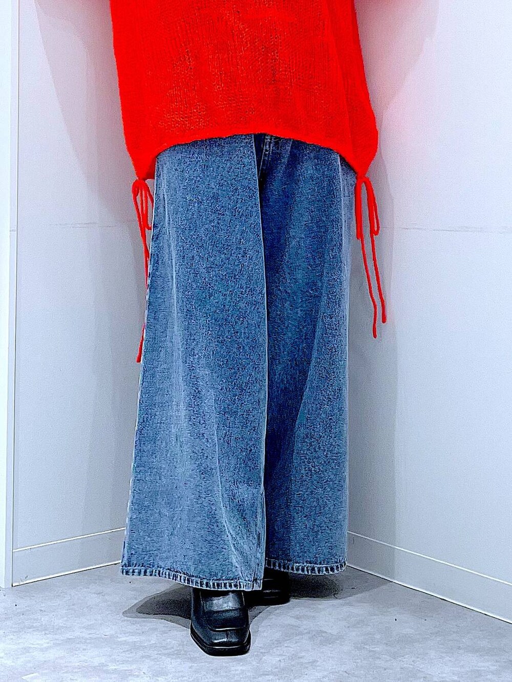 ブラウン系のショルダーバッグ、ブルー系のデニムパンツ、ブラック系のブーツを着用したレディースの秋コーディネートの8枚目の写真