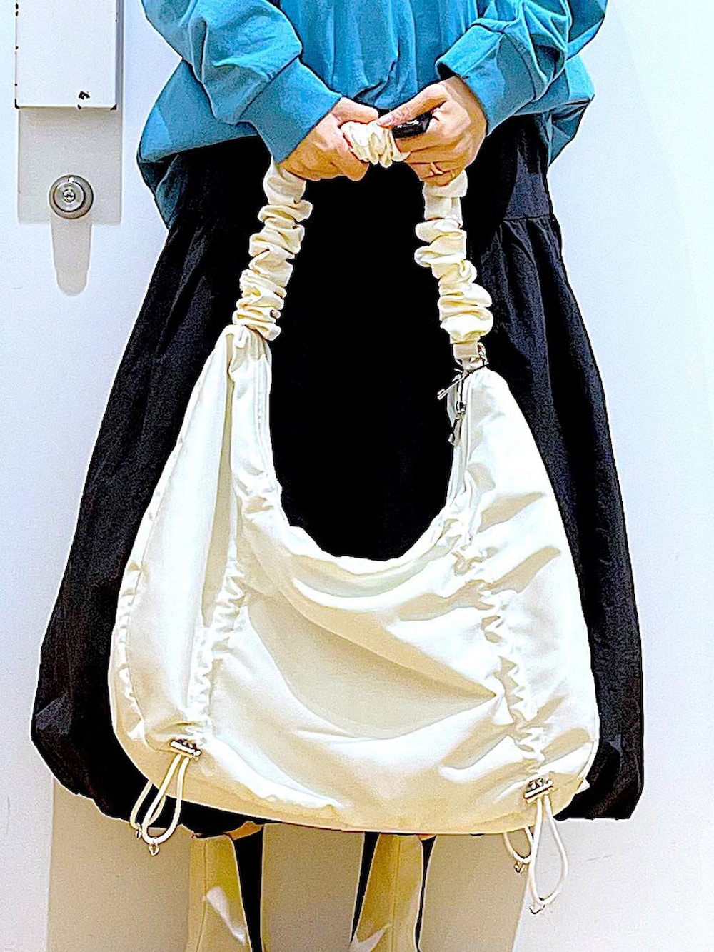 グリーン系のTシャツ/カットソー、ベージュ系のブーツ、ホワイト系のショルダーバッグを着用したレディースの春コーディネートの9枚目の写真