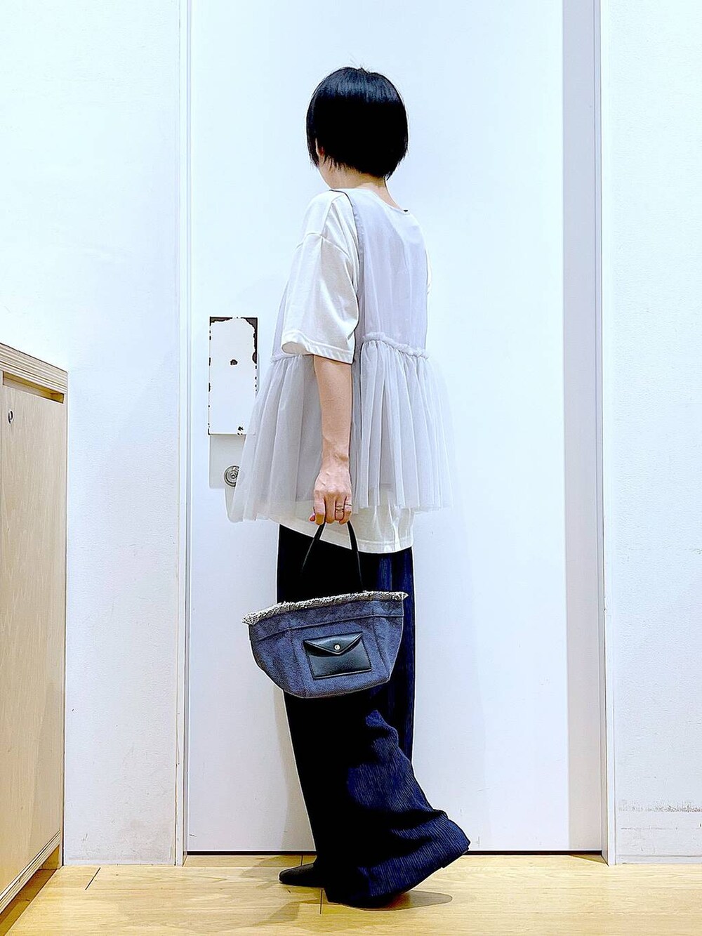 ブラック系のパンプス、ブルー系のショルダーバッグ、ホワイト系のTシャツ/カットソーを着用したレディースの夏コーディネートの3枚目の写真