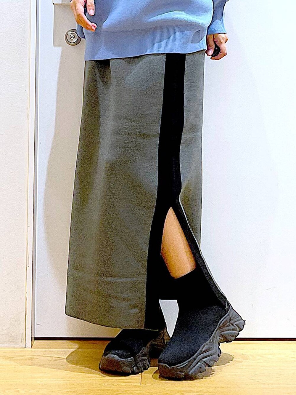 ブルー系のニット/セーター、ブラック系のショルダーバッグ、グレー系のスカートを着用したレディースの冬コーディネートの8枚目の写真