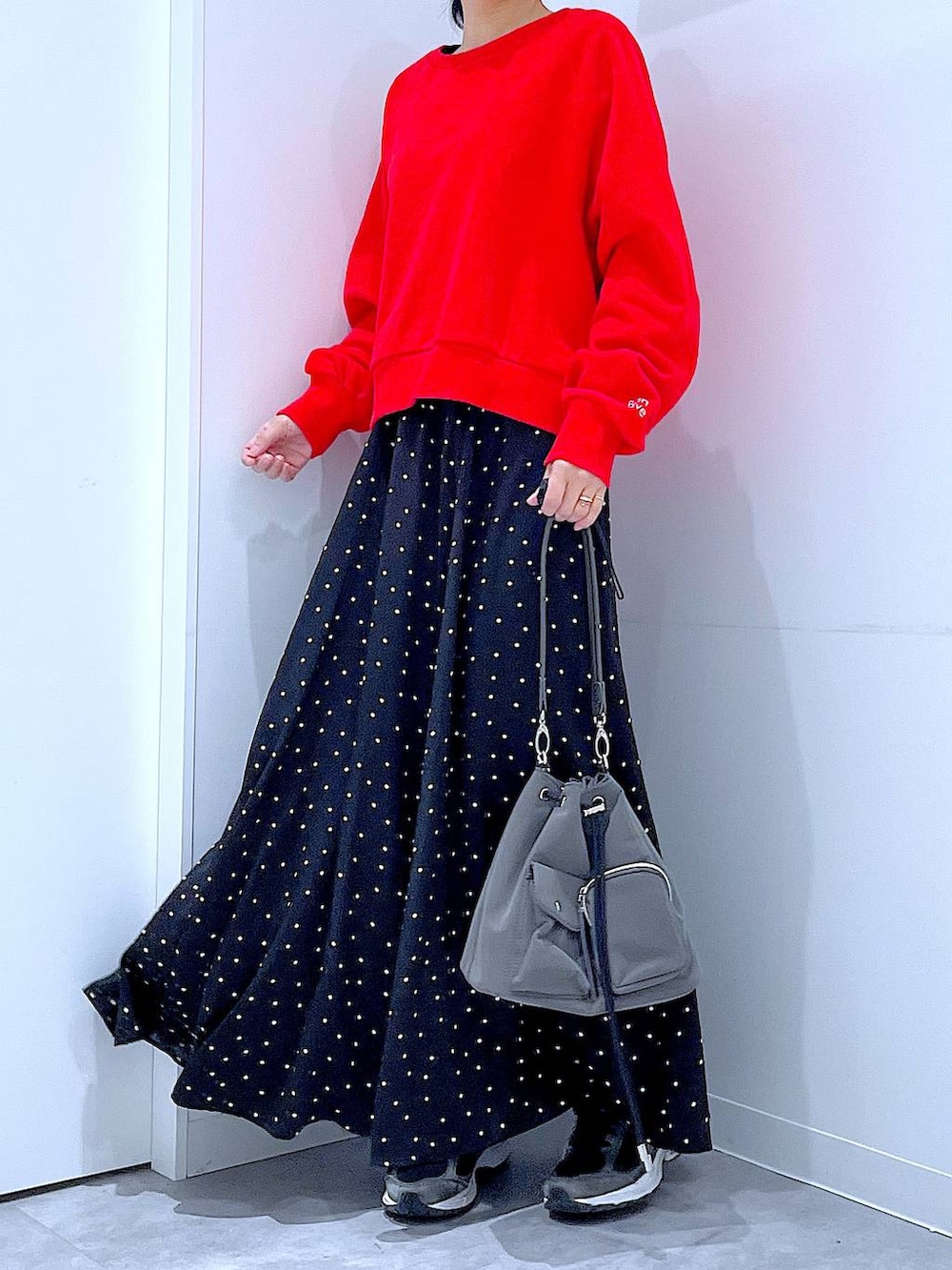 レッド系のスウェット、グレー系のシュシュを着用したレディースの春コーディネートの6枚目の写真