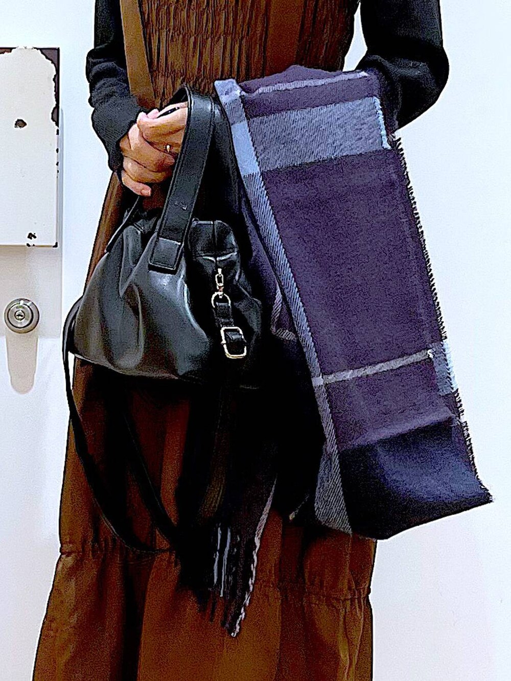 ブラック系のブーツ、ブラウン系のワンピース、ブラック系のショルダーバッグを着用したレディースの冬コーディネートの9枚目の写真