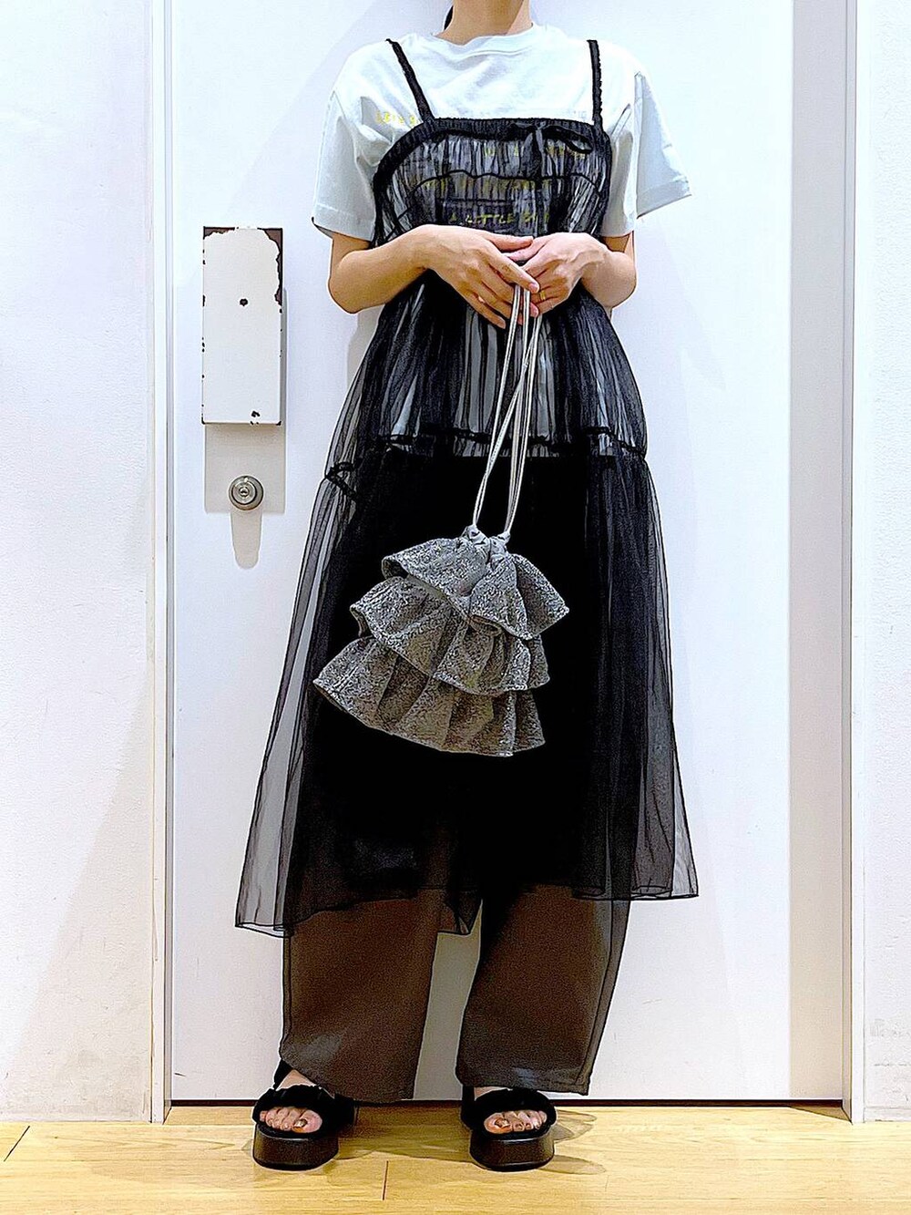 シルバー系のショルダーバッグ、グレー系のその他パンツ、ブラック系のサンダルを着用したレディースの夏コーディネートの6枚目の写真