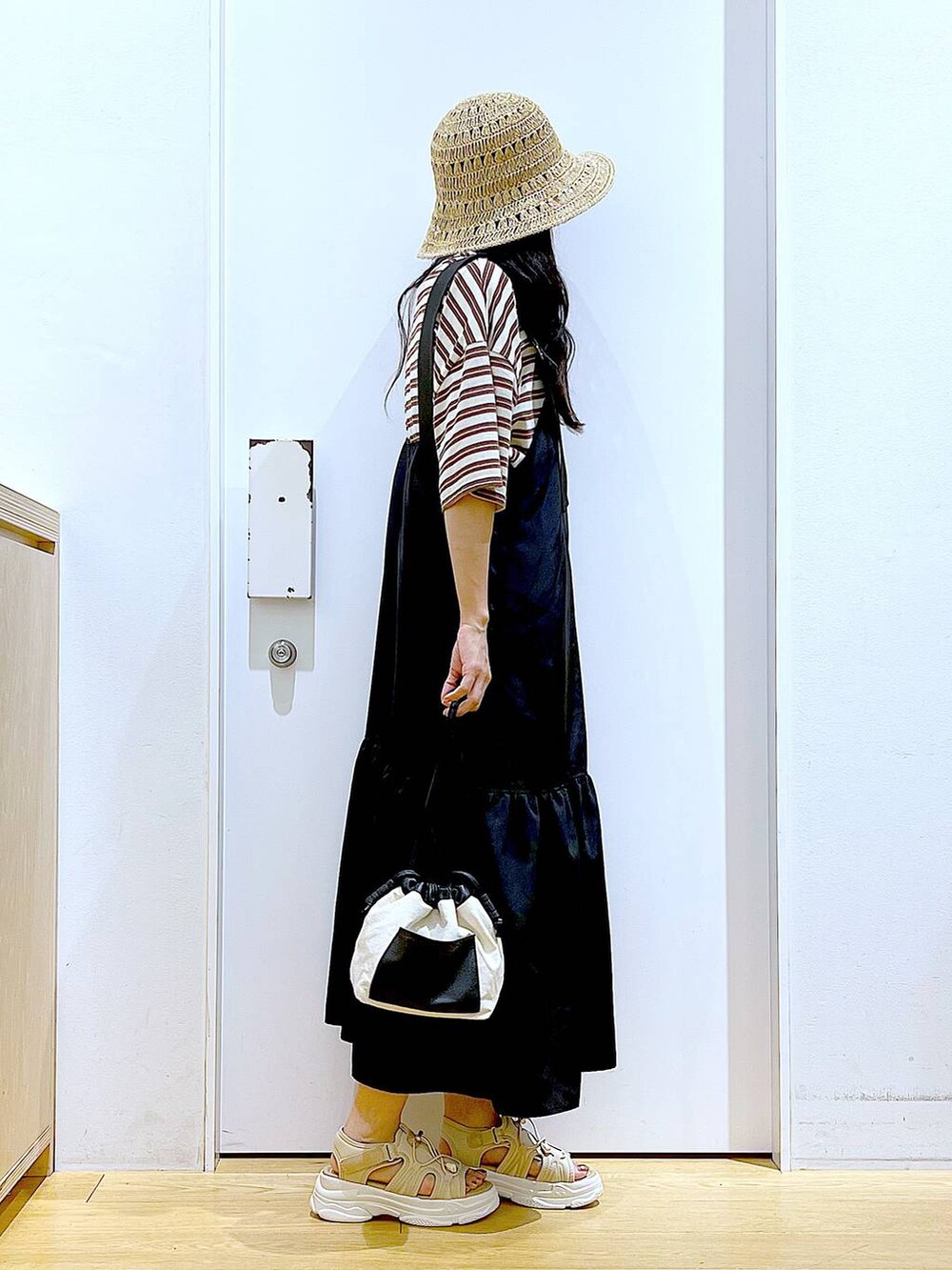 ホワイト系のショルダーバッグ、ブラック系のワンピース、ベージュ系のサンダルを着用したレディースの春コーディネートの4枚目の写真