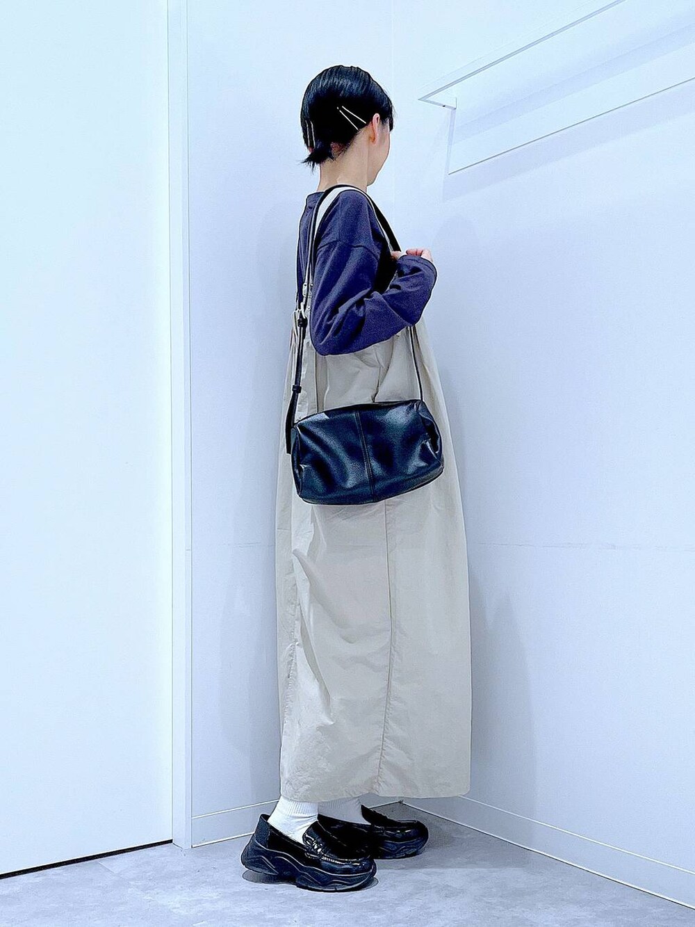 ブラック系のショルダーバッグ、ブラック系のローファー、グレー系のワンピースを着用したレディースの秋コーディネートの4枚目の写真