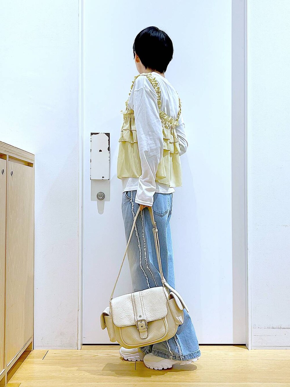 ホワイト系のスニーカー、ブルー系のデニムパンツ、ベージュ系のその他トップスを着用したレディースの春コーディネートの3枚目の写真