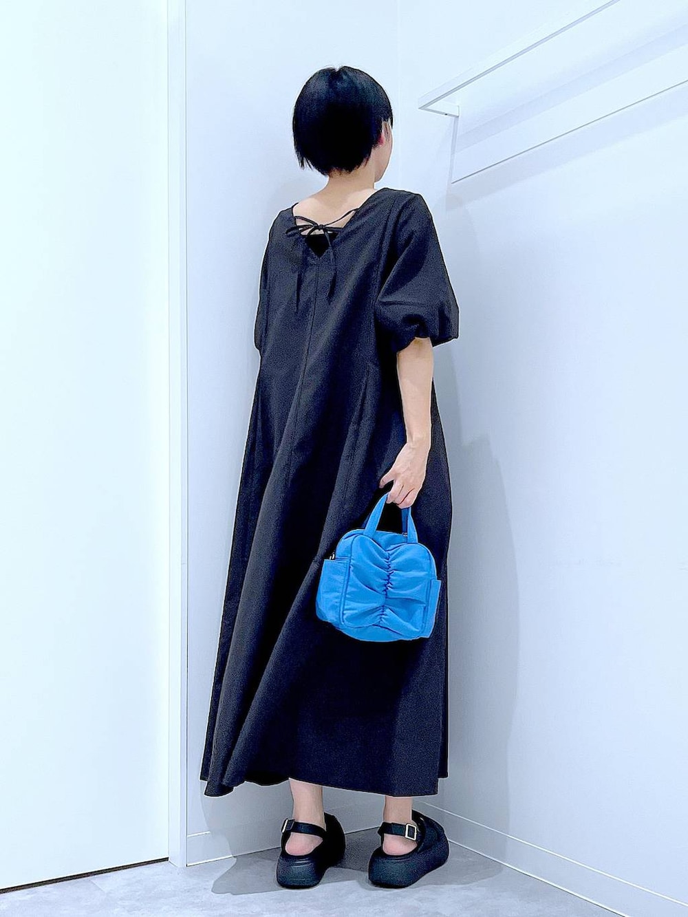 ブラック系のサンダル、ブラック系のワンピースを着用したレディースの夏コーディネートの5枚目の写真