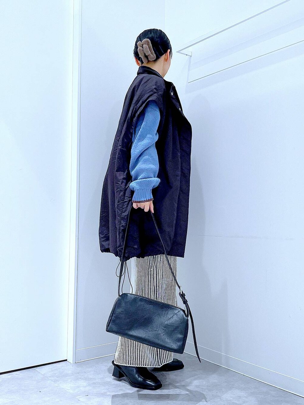 ブラック系のブルゾン、ベージュ系のスカート、ブラック系のブーツを着用したレディースの冬コーディネートの4枚目の写真