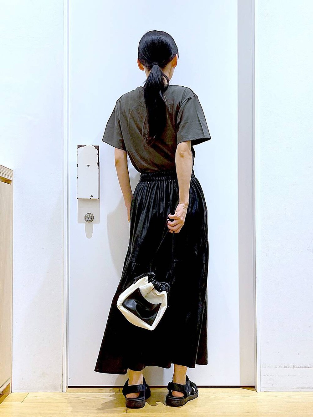 ホワイト系のショルダーバッグ、ブラック系のスリッポン、グレー系のTシャツ/カットソーを着用したレディースの夏コーディネートの5枚目の写真