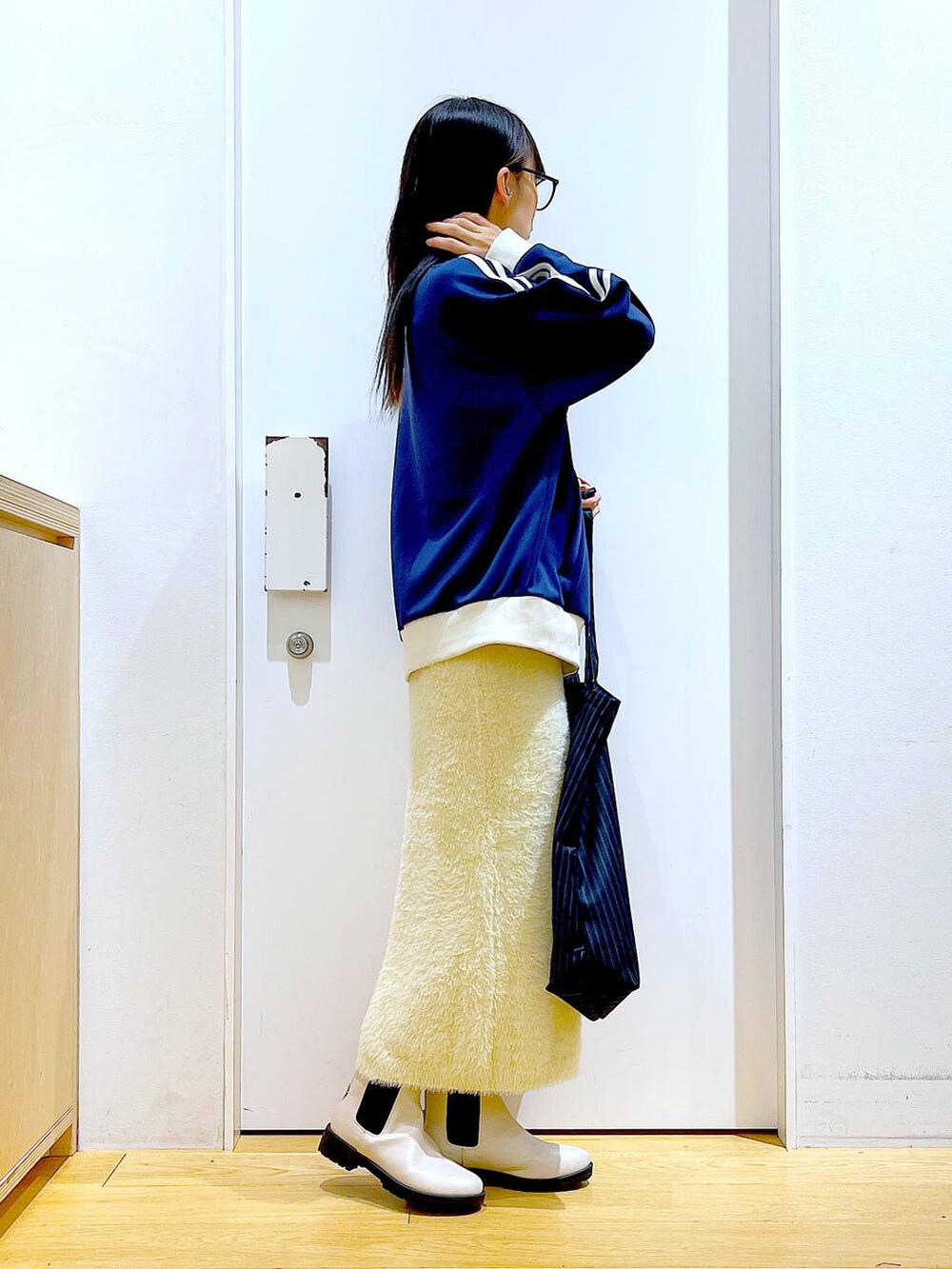 ベージュ系のブーツ、ブルー系のトートバッグ、ブルー系のスウェットを着用したレディースの冬コーディネートの4枚目の写真