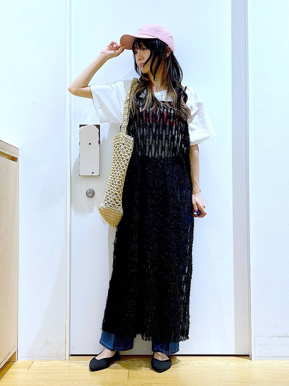 ブルー系のデニムパンツ、ブラック系のワンピース、ブラック系のパンプスを着用したレディースの春コーディネートの2枚目の写真